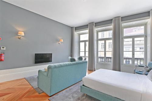 a bedroom with a bed and a couch and windows at Villa Mouzinho by ON Apartments in Porto