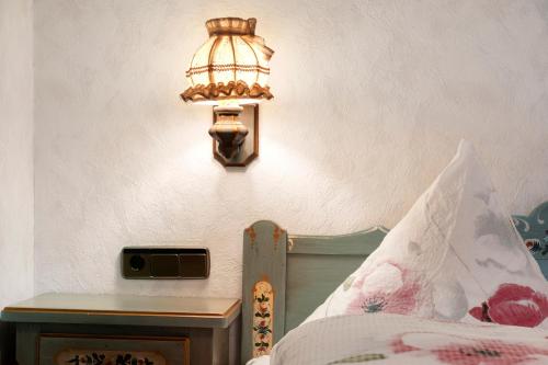 a lamp on a wall next to a bed at Gasthaus Heiligenbrunnen in Titisee-Neustadt