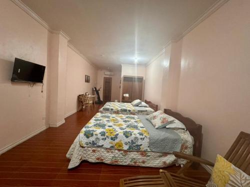 a bedroom with two beds and a tv on the wall at The Banahaw Inn Antique - near Antique Airport 