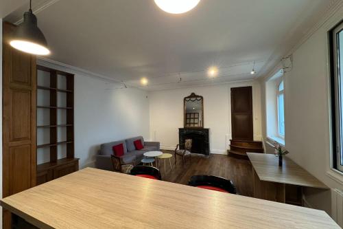 un salon avec une table et une cheminée dans l'établissement Charming apartment in the center of Caen, à Caen