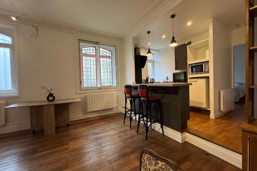 une cuisine avec un comptoir et des tabourets dans une pièce dans l'établissement Charming apartment in the center of Caen, à Caen
