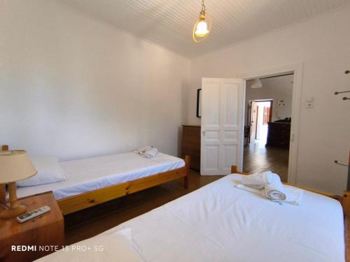 a bedroom with two beds and a table with a lamp at Studio Marianna in Oziás