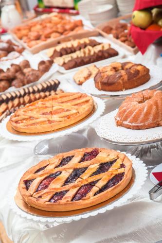 Ein Tisch mit Kuchen und anderem Gebäck auf Papptellern in der Unterkunft Hotel Nadir in Milano Marittima