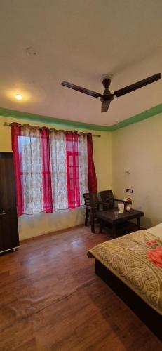 a bedroom with a bed and a ceiling fan at Mountain palace kargil in Kargil
