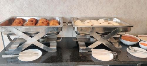 twee schalen met donuts en ander eten op een aanrecht bij Grand Manor Suites in Hyderabad