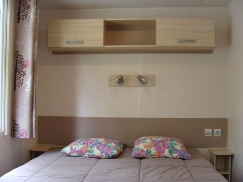 une chambre avec un lit avec deux oreillers dessus dans l'établissement le domaine de la grande veyiere, à Molières