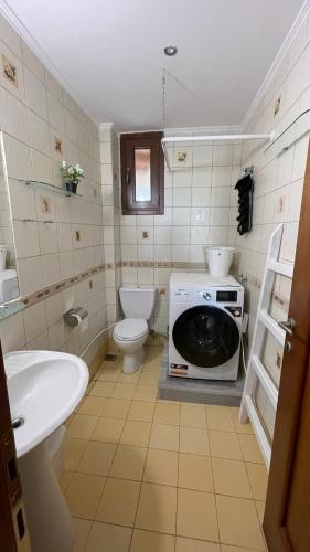 a bathroom with a toilet a sink and a microwave at Ira's House Afitos in Afitos