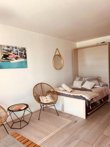 une chambre avec un lit avec un miroir et une chaise dans l'établissement Merveilleux Studio Face La Mer, à Royan