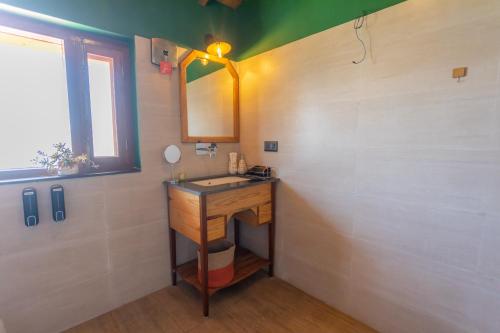 a bathroom with a sink and a mirror at Seclude Ramgarh Willows in Rāmgarh
