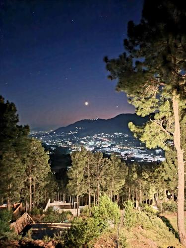 a view of a city from a mountain at night at Dera Qazi Family Studio Apartment in Abbottabad
