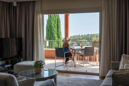 a woman sitting at a table in a living room at L'Hôtel & Spa du Castellet in Le Castellet