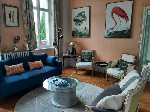 un salon avec un canapé bleu et des chaises dans l'établissement Belle demeure a 10 min de la mer, à Woincourt