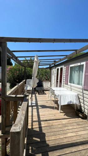 a deck with an umbrella and a table and chairs at Spacious chalet with furnished terrace in Fréjus