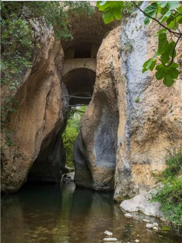 a bridge over a river in front of some rocks at ITALO b&b in Raiano