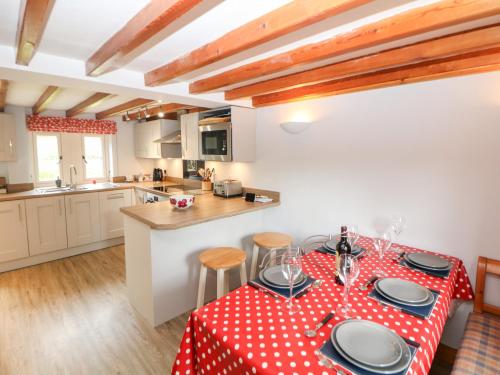 a kitchen with a table with a red and white table cloth at Trickett Gate Cottage in Castleton