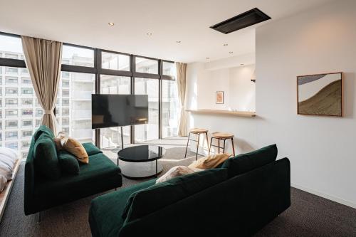 a living room with a couch and a tv at LUX by Hotel BAL in Fukuoka