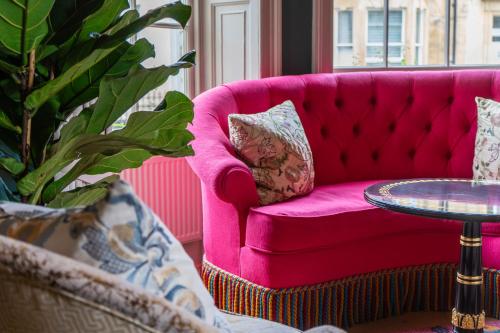 a pink couch in a living room with a table at Dukes Bath in Bath