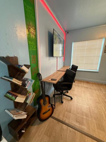 an office with a desk and a guitar in a room at OQP Vacations in Miami