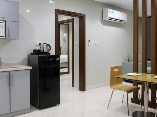 a kitchen with a black refrigerator and a table at Al Alamein Suites in Tabuk
