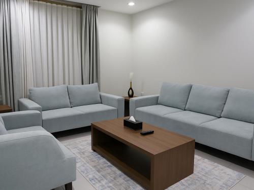 a living room with two couches and a coffee table at Al Alamein Suites in Tabuk