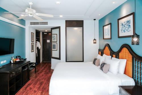 a bedroom with a white bed and a television at Away Chiang Mai Thapae Resort A Vegan Retreat in Chiang Mai