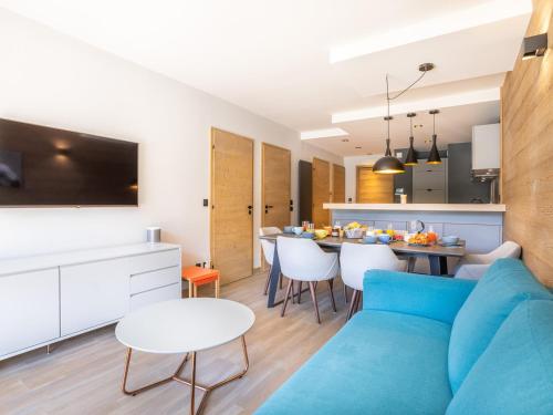 un salon avec un canapé bleu et une table dans l'établissement Appartement au centre de Tignes avec terrasse et Wifi - FR-1-641-82, à Tignes