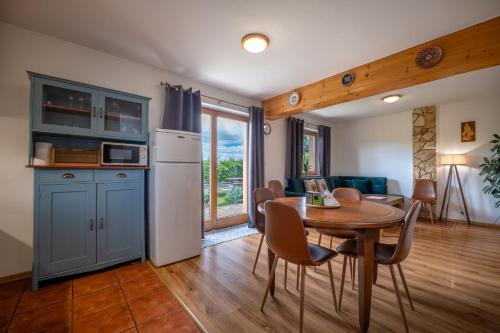 a kitchen and a dining room with a table and chairs at River Cottage Bešeňová in Bešeňová
