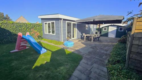 a small house with a slide in the yard at Hello Zeeland - Vakantiewoning Mariekerkseweg 1 in Meliskerke