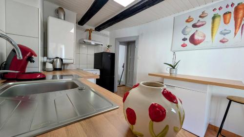 - une cuisine avec un évier et un vase sur le comptoir dans l'établissement Appartement centre de Barr, à Barr
