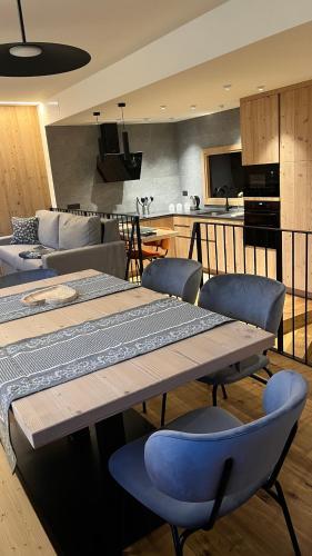 a living room with a table and chairs and a kitchen at Casa Lucia in Valdidentro