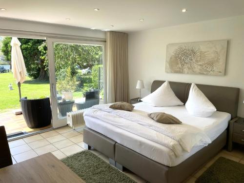 a bedroom with a large bed and a sliding glass door at Ferienwohnungen Lohmann in Bullay