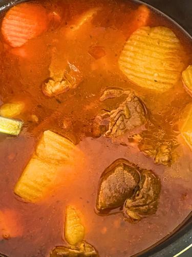 a pot of soup with meat and vegetables in it at LAM BUNGALOW Resort & Spa in Phu Quoc