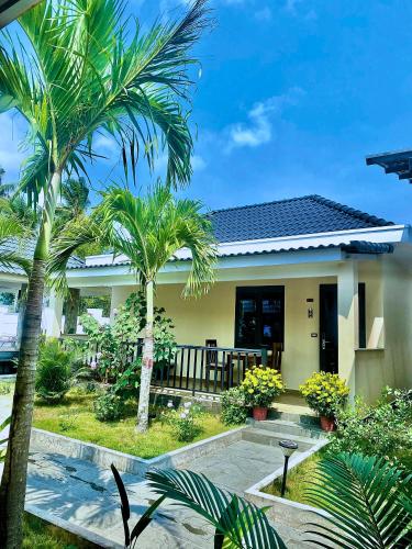 a house with palm trees in front of it at LAM BUNGALOW Resort & Spa in Phu Quoc