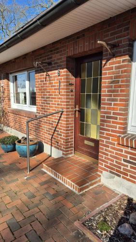 a brick house with a door and a brick patio at Ferienwohnung Hof Segberg in Langenberg