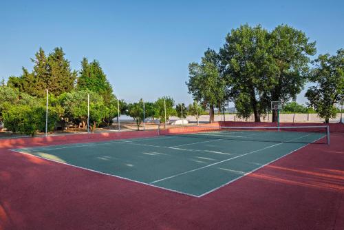 a tennis court with a net on top of it at The Grove Seaside Hotel in Dhrepanon