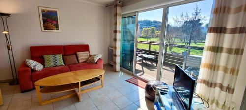 un salon avec un canapé rouge et une table dans l'établissement Spacious apartment with pool, à Saint-Raphaël