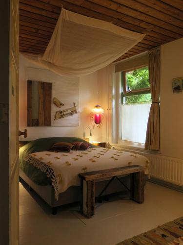 a bedroom with a large bed and a window at De Museumkamer in Den Burg