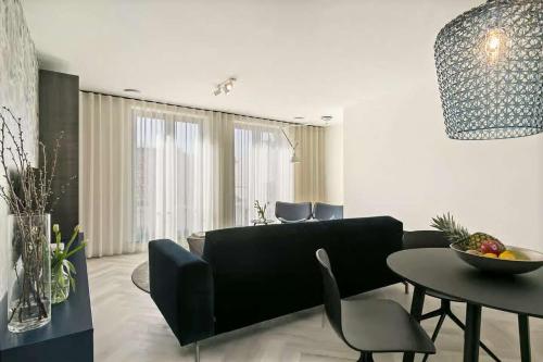 ドンブルグにあるHello Zeeland - Appartement Stationsstraat 5aの黒いソファとテーブルのあるリビングルーム