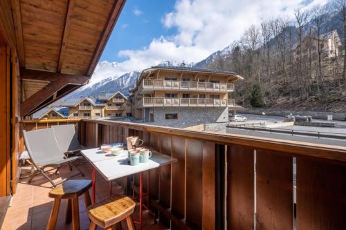 d'un balcon avec une table, des chaises et des montagnes. dans l'établissement Adorable apartment near the slopes Les Houches, aux Houches