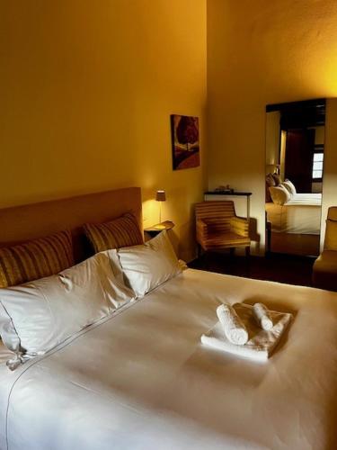 a bedroom with a white bed with two towels on it at Antico Borgo Delle Rose in Gricignano