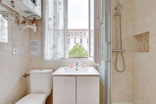 une salle de bain avec toilettes, lavabo et fenêtre dans l'établissement 121 - 4 Personnes Jeux Olympiques Stade de France, à Aubervilliers