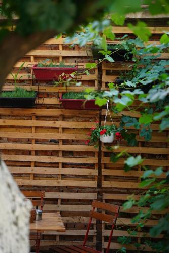 a wooden wall with potted plants and a table at Lemon House in Tirana