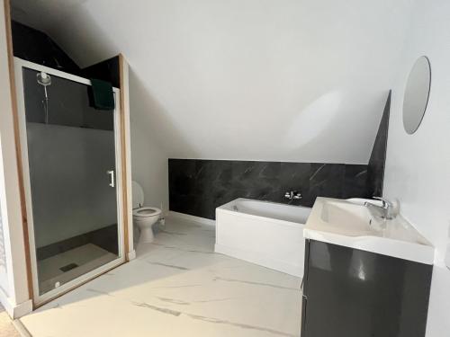 une salle de bain avec une baignoire, des toilettes et un lavabo dans l'établissement La maison de Joséphine, à 200m de la plage, à Saint-Aubin-sur-Mer