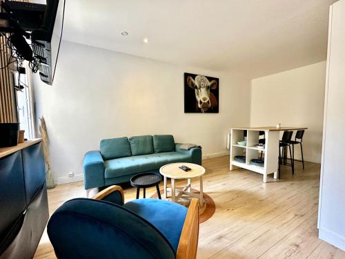 un salon avec un canapé bleu et une table dans l'établissement La maison de Joséphine, à 200m de la plage, à Saint-Aubin-sur-Mer