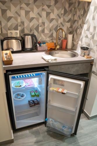 a kitchen with an open refrigerator next to a sink at Teatar Rooms Subotica 4 in Subotica