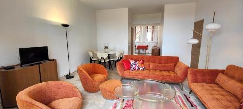 - un salon doté d'un mobilier orange et d'une table dans l'établissement Spacious T3 with balcony - beautiful sea view, à Saint-Raphaël