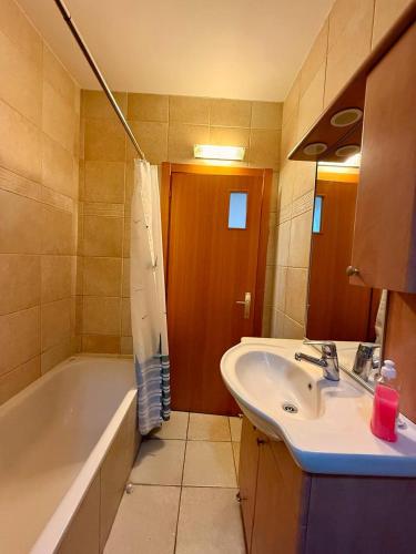 a bathroom with a tub and a sink and a bath tub at Royal King David Apartment in Netanya
