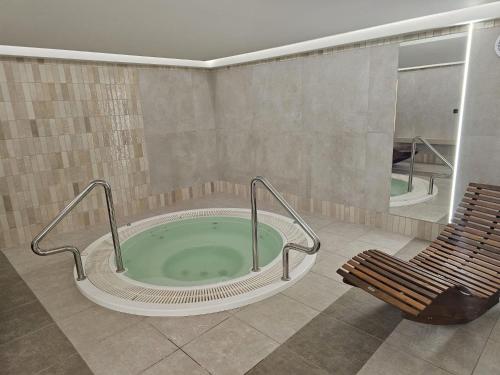 a hot tub in a room with a bench and a chair at Centrum Wypoczynkowo-Szkoleniowe Ostrzyce in Ostrzyce