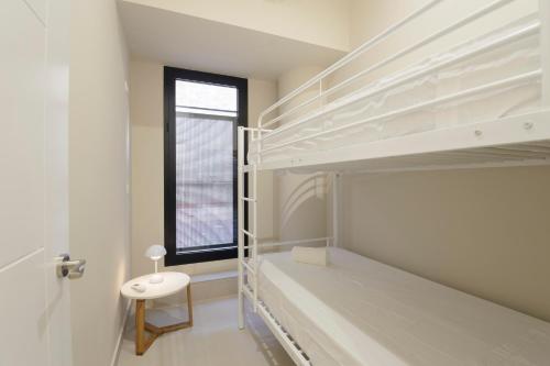 a bedroom with two bunk beds and a window at Apartamentos Constitución in Granada