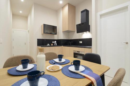 a dining room table with blue dishes and a bottle of milk at Apartamentos Constitución in Granada